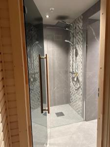 y baño con ducha y puerta de cristal. en Luksus i Riddergaarden, en Beitostølen