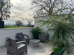 un patio con sillas, una mesa y una valla en Danelis Hotel, en Edelény