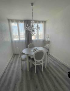 una sala da pranzo con tavolo e sedie bianchi di Appartement proche aéroport a Marignane