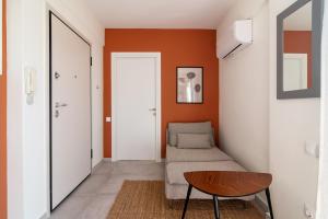 a living room with orange walls and a couch and a table at Cosy and stylish apartment in the centre in Athens