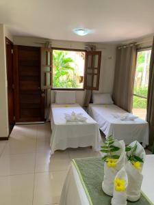 a room with two beds with flowers on them at Pousada Boa Vista in Barreirinhas