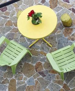 a yellow table and two chairs with a plant on it at Hello Skopje! in Skopje