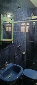 y baño con lavabo azul y aseo. en casas temporada em Tiradentes do mazinho en Tiradentes