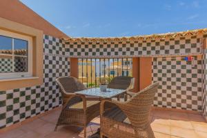 a patio with a table and wicker chairs at Charming Residence & Guest House Dom Manuel I Adults only in Lagos