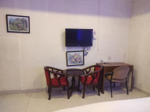 a room with a table and chairs and a tv at Mj birla international in Hyderabad