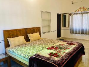 una camera da letto con un letto fiorito di Hotel tulsi palace a Pushkar