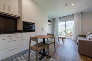 a kitchen and living room with a table and a couch at Quinta da Saraiva in Câmara de Lobos