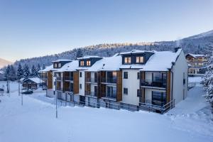 een appartementencomplex in de sneeuw met sneeuw bij Dolina Czyrna - doskonała lokalizacja dla narciarzy - Dream Apart in Szczyrk