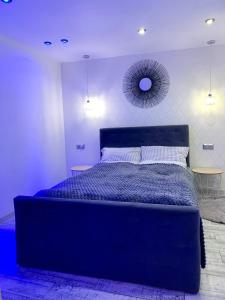 a bedroom with a blue bed and a mirror at Uroczy Apartament z Patio in Szczecin