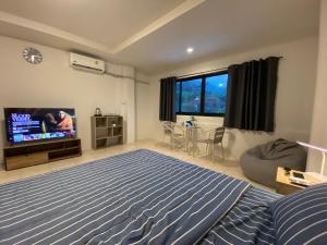 a bedroom with a bed and a flat screen tv at 84 Bar & Guest House Room 1 in Ban Huai Luk (1)