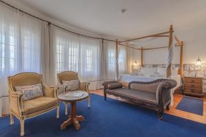 a bedroom with a canopy bed and two chairs at Charming Residence & Guest House Dom Manuel I Adults only in Lagos