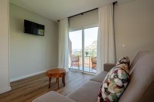 a living room with a couch and a sliding glass door at Quinta da Saraiva in Câmara de Lobos