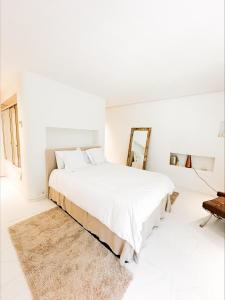 a white bedroom with a large bed and a mirror at LHV Luxury Apartment Boas in Ibiza Town