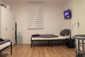 um quarto com uma cama e uma televisão na parede em Fully equipped Apartments em Bönnigheim