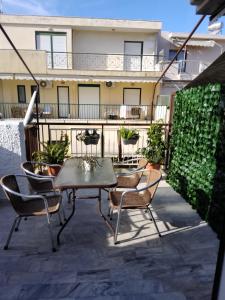 a patio with a table and chairs on a balcony at Volos Hospitality, Central Apartment in Volos