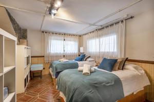 um quarto com três camas num quarto em Casa de Amigos La Latina con chimenea y barbacoa em Illora