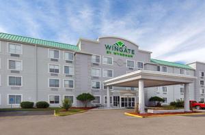 a white hotel with a sign on the front of it at Wingate by Wyndham Hattiesburg in Hattiesburg