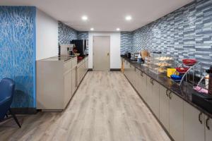 a kitchen with white cabinets and blue tiles at Days Inn & Suites by Wyndham Northwest Indianapolis in Indianapolis