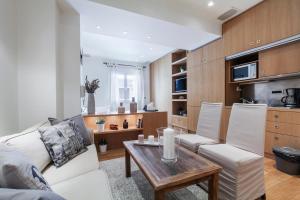 a living room with a white couch and a table at Hilton Area 1BR Executive Flat in Athens
