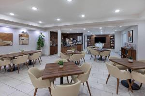 a restaurant with tables and chairs in a room at Wingate by Wyndham Hattiesburg in Hattiesburg