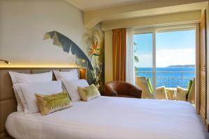 a bedroom with a large bed with a view of the ocean at Best Western Premier Montfleuri in Sainte-Maxime