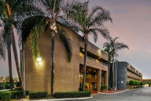 un edificio con palmeras delante en Travelodge by Wyndham Commerce Los Angeles Area, en Commerce