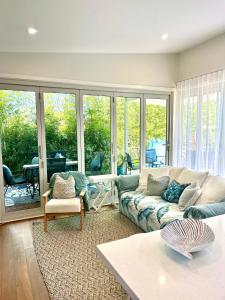 una sala de estar con un sofá y una mesa en Woonona Family Beach Villa 2 bedroom Brand new, en Woonona