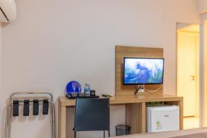 Uma TV ou centro de entretenimento em Rio Stay - Flat's - Rio Centro