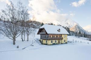 una casa en la nieve frente a una montaña en Landhaus Stieglschuster, 