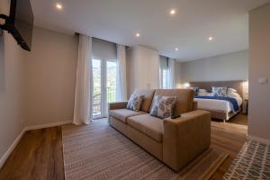 a living room with a couch and a bed at Quinta da Saraiva in Câmara de Lobos