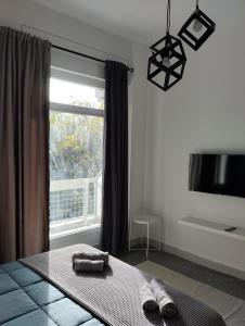 1 dormitorio con 1 cama con 2 toallas y una ventana en PANSEA 03 IsimeriaHomz en Tesalónica