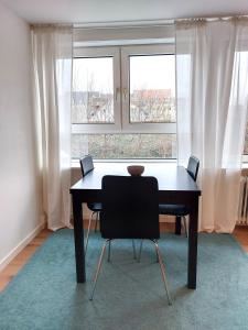 a table and two chairs in a room with a window at Nordic style apartment in central Aalborg in Aalborg