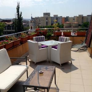 a patio with chairs and a table on a balcony at Penthouse City Centre in Iaşi