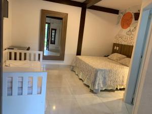 una camera con letto e specchio di Salvetti Praia Hotel a Boracéia