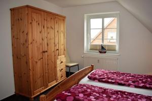 a bedroom with two beds and a dresser and a window at Uthlande in Dagebüll