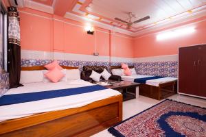 2 Betten in einem Zimmer mit orangefarbenen Wänden in der Unterkunft Raja Hotel & Lodge - Kharagpur, West Bengal in Shyāmalpur