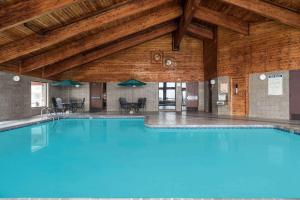 a large swimming pool in a building with a wooden ceiling at AmericInn by Wyndham Tofte Near Lake Superior in Tofte