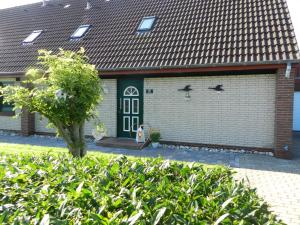 a house with a garage with a green door at Daisy in Dagebüll