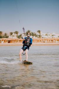 een man op een plank in het water bij Regency Plaza Aqua Park and Spa Resort in Sharm El Sheikh