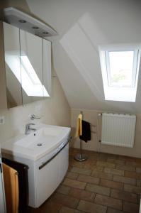 a white bathroom with a sink and a skylight at Daisy in Dagebüll