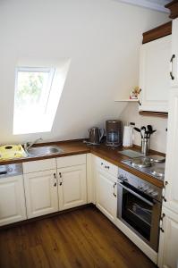 a kitchen with white cabinets and a sink at Daisy in Dagebüll