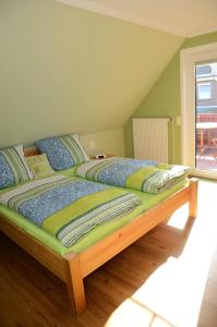 a large bed in a room with a window at Daisy in Dagebüll