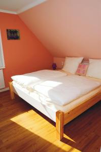 een groot bed in een kamer met een oranje muur bij Daisy in Dagebüll