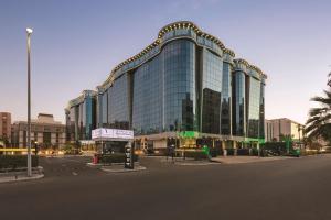 a large building with glass windows on a street at Vivid Jeddah Hotel, a member of Radisson Individuals in Jeddah