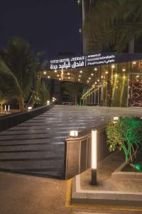 a walkway leading to a building at night at Vivid Jeddah Hotel, a member of Radisson Individuals in Jeddah