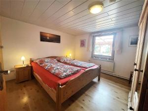 1 dormitorio con 1 cama en una habitación con ventana en Bellos Ferienbungalow, Hunde willkommen, Sauna, WLAN, eingezäunt, Strandkorb, Zwinger, 