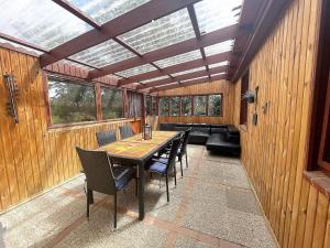 a screened in porch with a table and chairs at Bellos Ferienbungalow, Hunde willkommen, Sauna, WLAN, eingezäunt, Strandkorb, Zwinger 