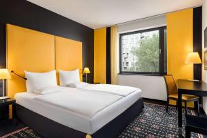 ein Hotelzimmer mit einem großen Bett und einem Schreibtisch in der Unterkunft Vienna House Easy by Wyndham Katowice in Kattowitz + 92 Fotos
