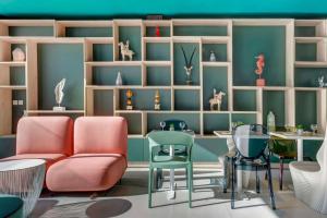 un soggiorno con sedie, tavoli e scaffali di Quadro Hotel, Trademark Collection by Wyndham a San Giuliano