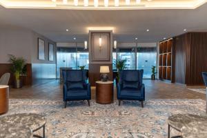 un vestíbulo con 2 sillas azules y una mesa en Radisson Blu Hotel, Amman Galleria Mall en Amán